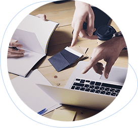 three business people strategizing with a laptop and notebooks